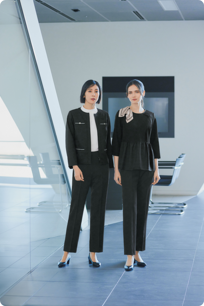 ENJOY Noirの黒色の制服を着用し、立っているカーディーラーの2名の女性スタッフ